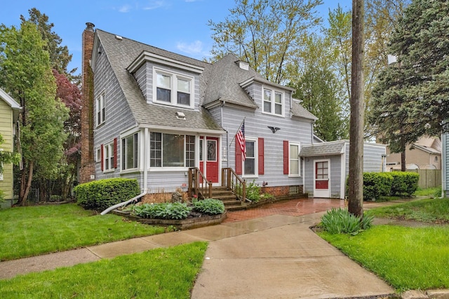 449 Spruce St, Wyandotte, MI 48192 - view of front facade featuring a chimney, roof with shingles, and a front yard