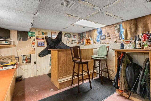 449 Spruce St, Wyandotte, MI 48192 - indoor dry bar with a paneled ceiling, wooden walls, and finished concrete floors