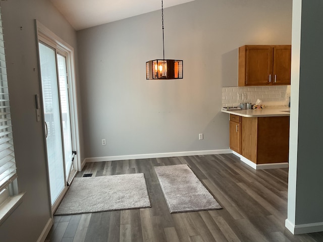 6561 Deerhurst Dr, Westland, MI 48185 - unfurnished dining area with dark wood-type flooring and baseboards
