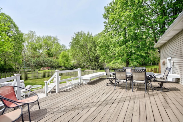 7361 N Shore Dr, South Haven, MI 49090 - wooden deck with outdoor dining space and view of wooded area