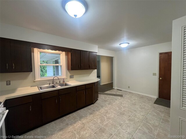 1420 Jones, Port Huron, MI 48060 - kitchen featuring a sink, light countertops, dark brown cabinets, and baseboards