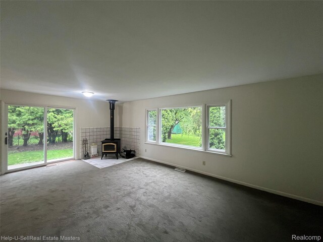 1420 Jones, Port Huron, MI 48060 - unfurnished living room with a wood stove, carpet flooring, and baseboards