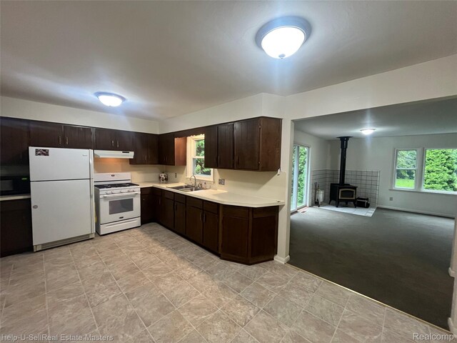 1420 Jones, Port Huron, MI 48060 - kitchen featuring white appliances, a sink, a wood stove, dark brown cabinets, and light countertops