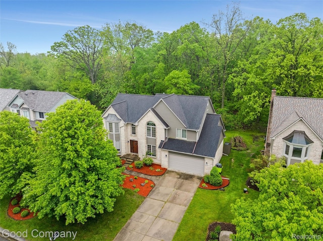 5893 Christina Dr, West Bloomfield, MI 48324 - view of front facade with concrete driveway, a front yard, and a garage