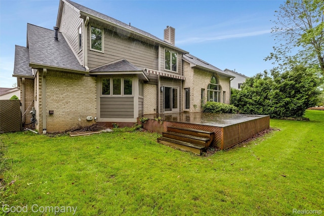 5893 Christina Dr, West Bloomfield, MI 48324 - rear view of property with a deck, a yard, a chimney, brick siding, and a shingled roof