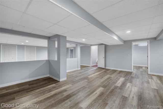 5893 Christina Dr, West Bloomfield, MI 48324 - finished below grade area with a drop ceiling, wood finished floors, and baseboards
