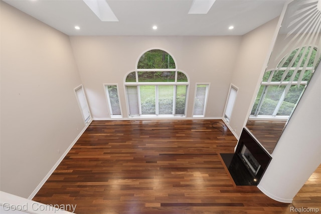 5893 Christina Dr, West Bloomfield, MI 48324 - unfurnished room featuring a skylight, wood finished floors, a towering ceiling, recessed lighting, and baseboards