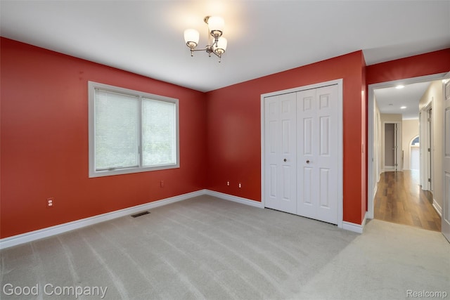5893 Christina Dr, West Bloomfield, MI 48324 - unfurnished bedroom featuring light carpet, baseboards, a chandelier, and a closet