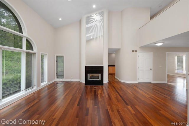 5893 Christina Dr, West Bloomfield, MI 48324 - unfurnished living room featuring high vaulted ceiling, a multi sided fireplace, wood finished floors, baseboards, and recessed lighting
