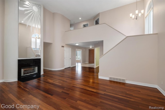 5893 Christina Dr, West Bloomfield, MI 48324 - unfurnished living room with wood finished floors, a chandelier, a towering ceiling, baseboards, and recessed lighting