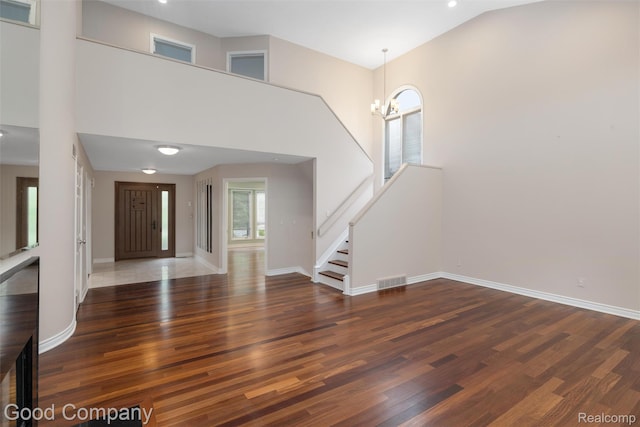 5893 Christina Dr, West Bloomfield, MI 48324 - entryway with wood finished floors, baseboards, a chandelier, stairs, and a towering ceiling