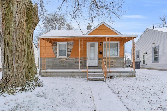 19165 Roger St, Melvindale, MI 48122 - view of front facade with a porch, stone siding, and a chimney