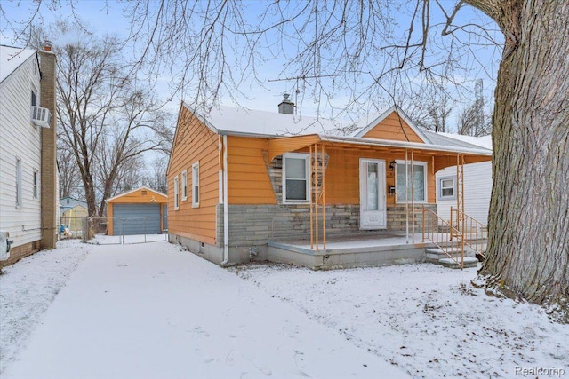 19165 Roger St, Melvindale, MI 48122 - view of front of home featuring an outdoor structure, a detached garage, covered porch, a chimney, and stone siding