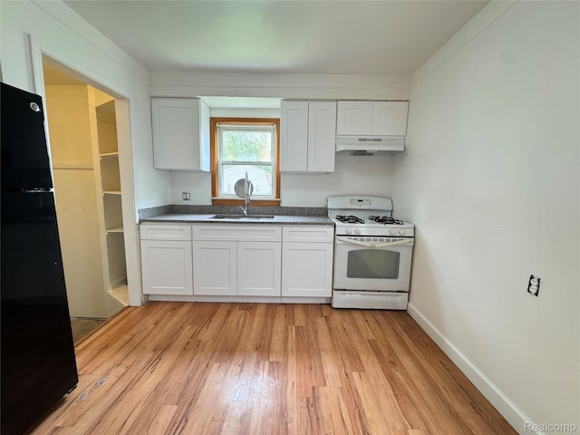 19165 Roger St, Melvindale, MI 48122 - kitchen featuring white range with gas stovetop, under cabinet range hood, freestanding refrigerator, light wood-style floors, and white cabinets