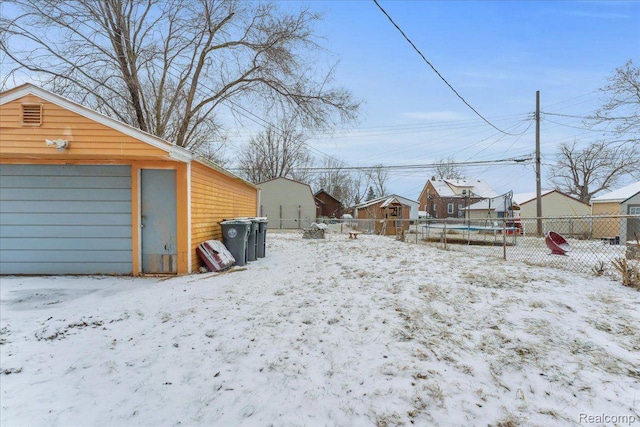 19165 Roger St, Melvindale, MI 48122 - yard covered in snow with a trampoline, an outbuilding, and a garage