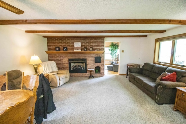 living area with beam ceiling, light carpet, a textured ceiling, and a fireplace