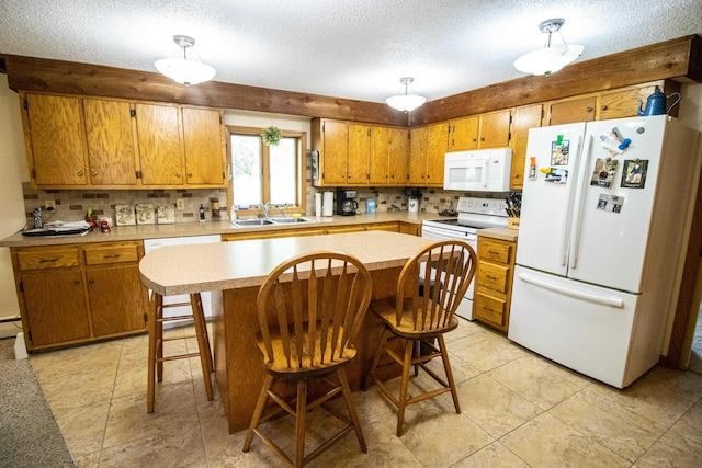 kitchen with white appliances, a sink, light countertops, backsplash, and a textured ceiling