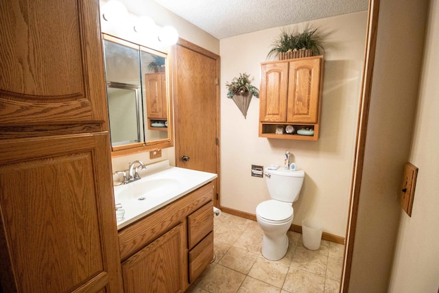 full bathroom with vanity, an enclosed shower, toilet, baseboards, and a textured ceiling