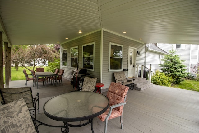 view of patio with outdoor dining area, a deck, and a grill