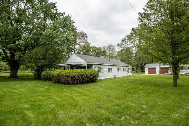 view of green lawn with an outdoor structure, view of scattered trees, and a garage