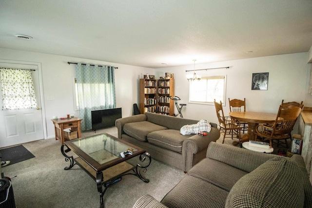 carpeted living area featuring a chandelier