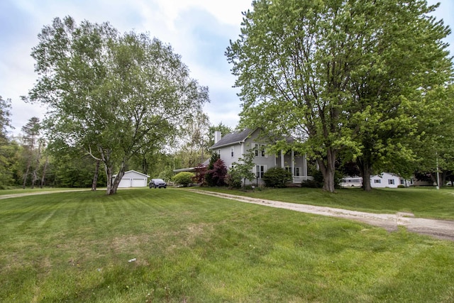 view of green lawn featuring an outbuilding and a garage