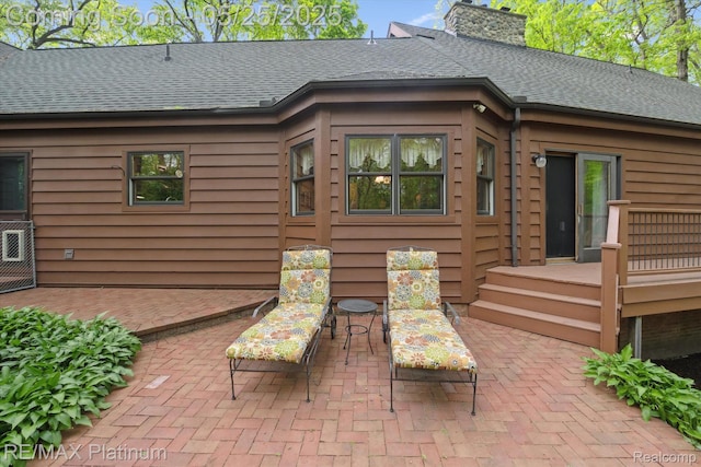 4121 Marsh Trl, Milford, MI 48380 - back of property with a patio, roof with shingles, a chimney, and a wooden deck