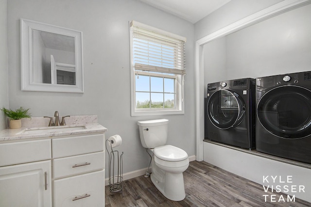 9020 5 Mile Rd NE, Ada, MI 49301 - bathroom featuring separate washer and dryer, toilet, wood finished floors, vanity, and baseboards