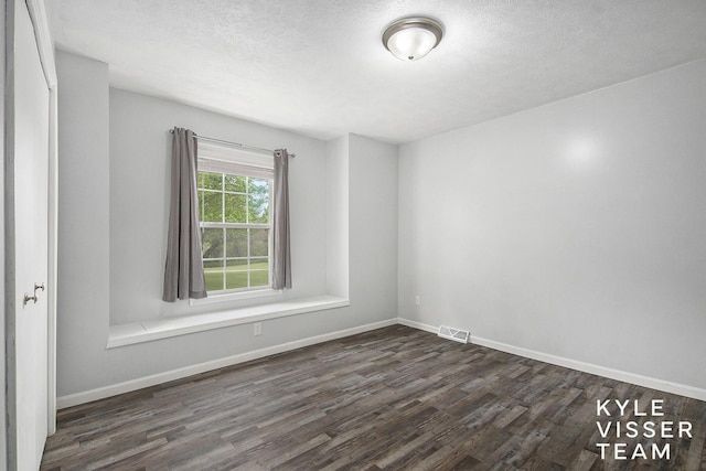 9020 5 Mile Rd NE, Ada, MI 49301 - empty room featuring dark wood-style flooring, baseboards, and a textured ceiling