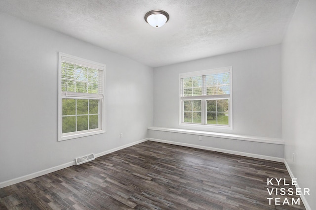 9020 5 Mile Rd NE, Ada, MI 49301 - spare room featuring plenty of natural light, dark wood-style floors, a textured ceiling, and baseboards