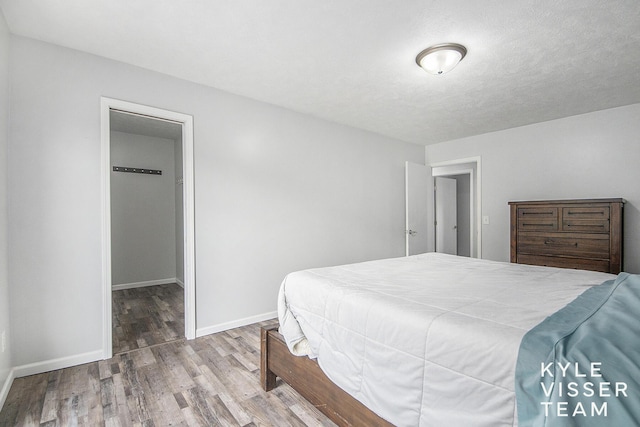 9020 5 Mile Rd NE, Ada, MI 49301 - bedroom featuring wood finished floors, baseboards, and a spacious closet