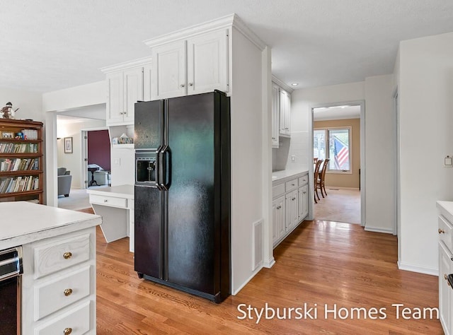 2490 Persimmon Pl NE, Belmont, MI 49306 - kitchen with black refrigerator with ice dispenser, light wood-style floors, light countertops, and white cabinets