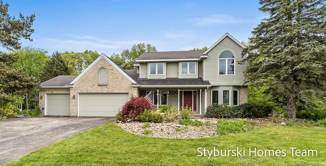 2490 Persimmon Pl NE, Belmont, MI 49306 - traditional-style home featuring asphalt driveway, a garage, a front yard, and brick siding