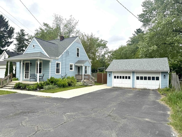 8251 Secor Rd, Lambertville, MI 48144 - view of front of house with a detached garage, a porch, an outdoor structure, a chimney, and a shingled roof