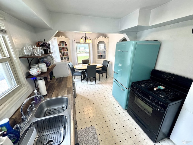 8251 Secor Rd, Lambertville, MI 48144 - kitchen featuring black range with gas cooktop, light flooring, a chandelier, and healthy amount of natural light