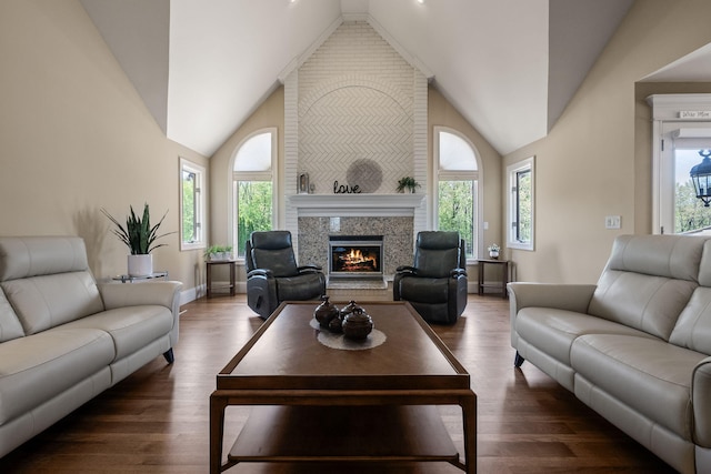 4624 Parman Rd, Stockbridge, MI 49285 - living room with vaulted ceiling, a warm lit fireplace, wood finished floors, and baseboards