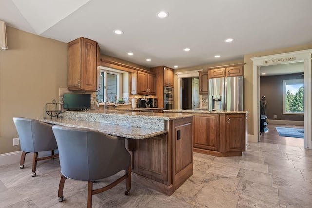 4624 Parman Rd, Stockbridge, MI 49285 - kitchen with appliances with stainless steel finishes, a peninsula, baseboards, light stone countertops, and recessed lighting