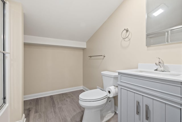 4624 Parman Rd, Stockbridge, MI 49285 - full bath with vaulted ceiling, toilet, vanity, wood finished floors, and baseboards