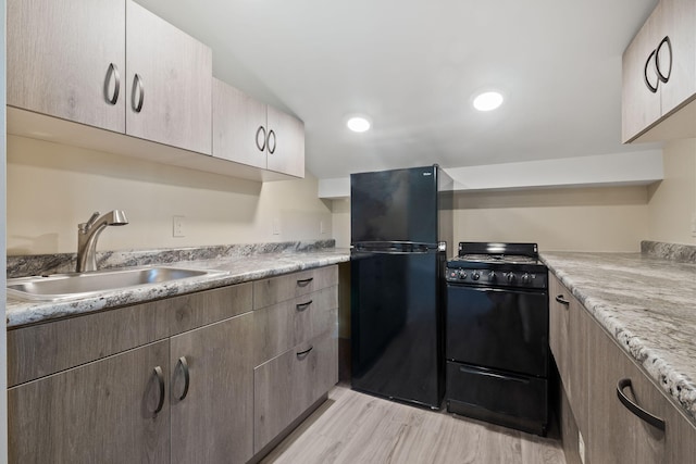 4624 Parman Rd, Stockbridge, MI 49285 - kitchen with black appliances, a sink, and light wood finished floors