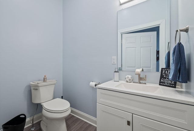 4624 Parman Rd, Stockbridge, MI 49285 - half bathroom with baseboards, toilet, wood finished floors, and vanity