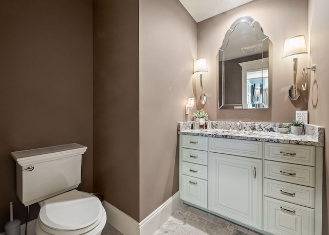 4624 Parman Rd, Stockbridge, MI 49285 - bathroom featuring baseboards, toilet, vanity, and stone finish floors