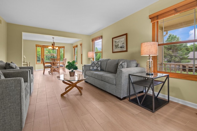 4900 Grass Lake Rd, White Lake, MI 48383 - living area with a chandelier, light wood finished floors, and baseboards