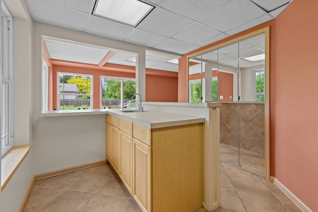 4900 Grass Lake Rd, White Lake, MI 48383 - kitchen featuring light brown cabinetry, a sink, light tile patterned flooring, a drop ceiling, and baseboards