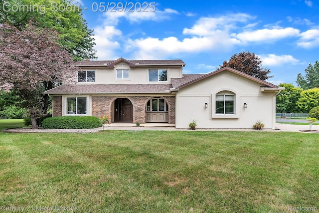 2232 Hayward St, Clio, MI 48420 - traditional home featuring a front yard, stucco siding, and a porch