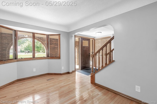 2232 Hayward St, Clio, MI 48420 - entryway with arched walkways, baseboards, light wood-type flooring, and a textured ceiling