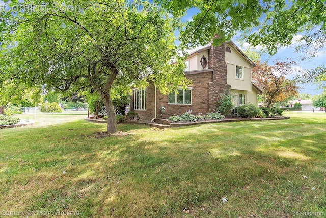 2232 Hayward St, Clio, MI 48420 - view of side of home with a lawn, brick siding, and stucco siding