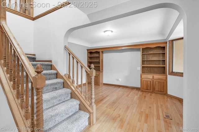 2232 Hayward St, Clio, MI 48420 - stairs with arched walkways, hardwood / wood-style floors, and baseboards