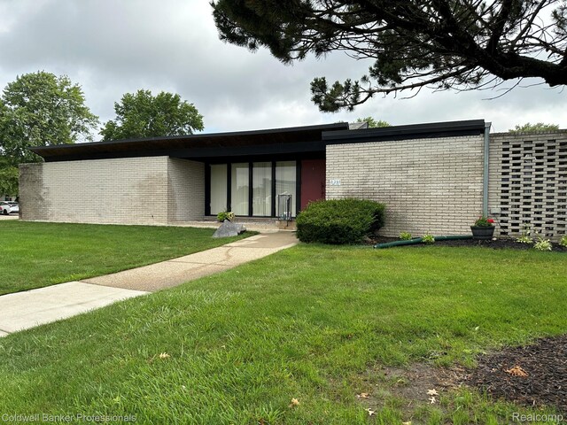 8401 Kennedy Cir N Unit 7, Warren, MI 48093 - doorway to property with brick siding and a lawn
