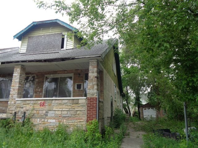 14876 Wisconsin St, Detroit, MI 48238 - view of front of property featuring stone siding, covered porch, and roof with shingles
