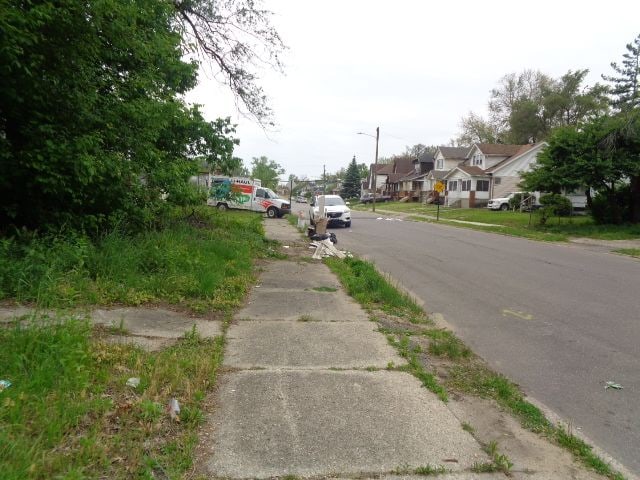 14876 Wisconsin St, Detroit, MI 48238 - view of asphalt road with sidewalks, a residential view, and street lights